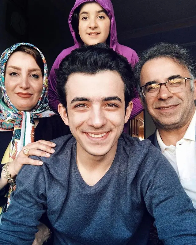 علی شادمان در کنار پدر و مادر و خواهرش با عکس
