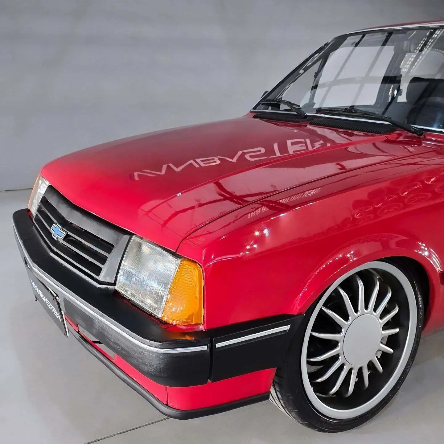 نمای خارجی خودروی شورولت شوت (GM Chevette SL) مدل ۱۹۸۹ به رنگ نوک‌مدادی با رینگ‌های اسپرت ۱۷ اینچی و چراغ‌های اورجینال در وضعیت بسیار سالم.