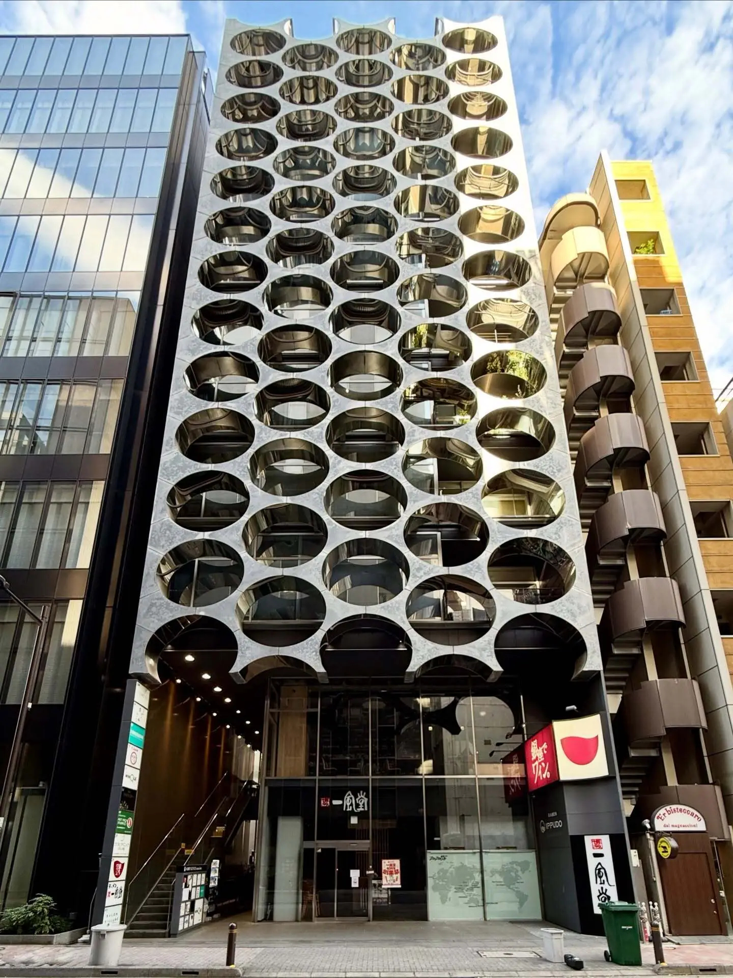 نمای خارجی ساختمان آلفا ماتریکس در توکیو اثر تاکتو شیموهیگوشی، با قاب‌های فلزی مستطیلی و پنل‌های شیشه‌ای مدرن در منطقه گینزا.